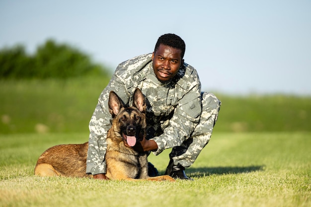 訓練キャンプで自由時間を楽しむ軍用犬と兵士の指揮官