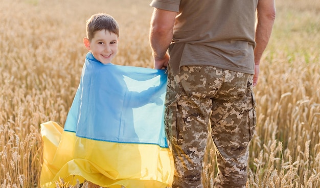 ウクライナの旗を持つ軍人の子供