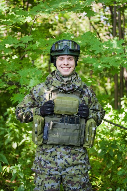 A military man in the forest with a machine gun in peacetime.\
preparing the military for hostilities.