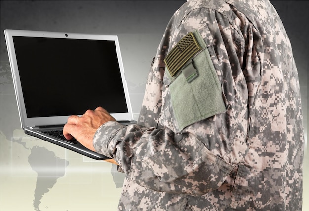 military man holding laptop