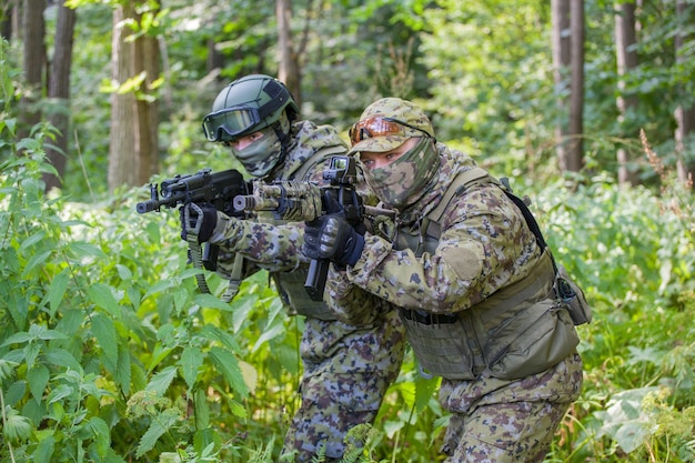 Military men in the forest with a machine gun. Soldiers are ready for action