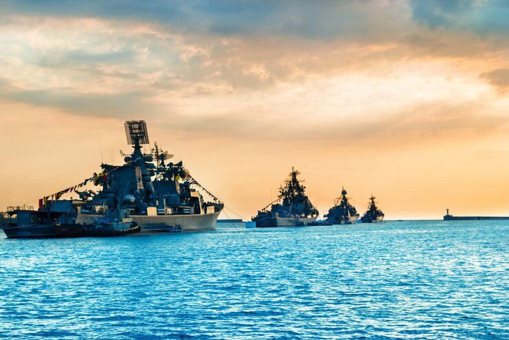 Photo military navy ships in a sea bay at sunset time