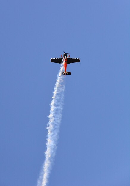 軍用機が青空に煙を上げて飛んでくる