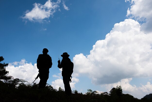 Photo military silhouettes of soldiers ready his weapon.