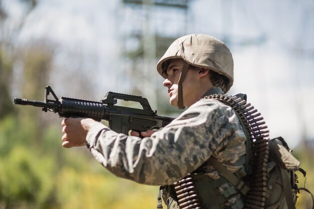 Military soldier aiming with a rifle in boot camp
