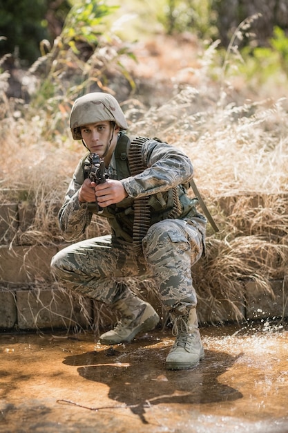 Foto soldato militare che mira con un fucile nel campo di addestramento