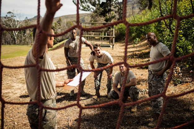 Military soldiers interacting with each other near fitness trial