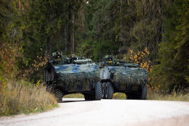 Military training on the battlefield with armored vehicles drives on forest road Army war concept