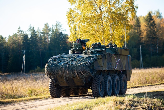 Military training on the battlefield with armored vehicles drives on forest road Army war concept