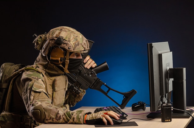 The military in uniform sitting at a computer conducts cyber warfare