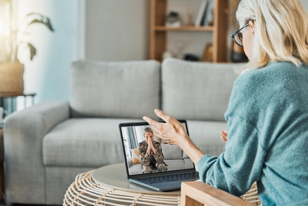 Foto donna militare in videochiamata con psicologa per problemi di salute mentale ansia e trauma con tecnologia virtuale dello schermo del laptop soldato o veterano che si consulta con la terapia psicologica nella chiamata zoom