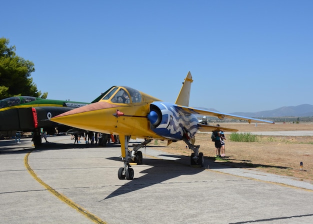 Un jet da combattimento giallo militare si trova sulla pista di un aeroporto militare in grecia