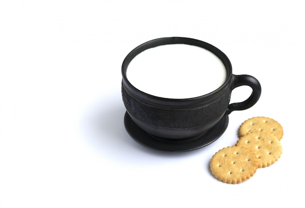 Milk in a black mug and cookies