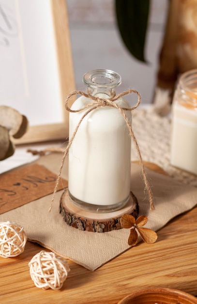 Milk in a bottle with a bow on a light background