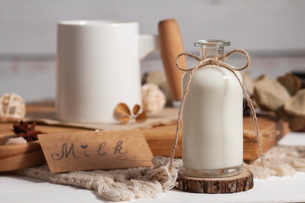 Milk in a bottle with a bow on a light background