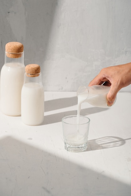 Бутылки молока на белом столе