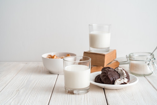 Milk breakfast with crackers and marshmallows on a white background with books.