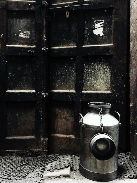Photo milk canister by closed metal door