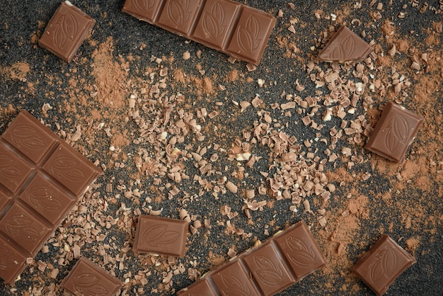 Scaglie di cioccolato al cioccolato al latte e cacao su superficie nera