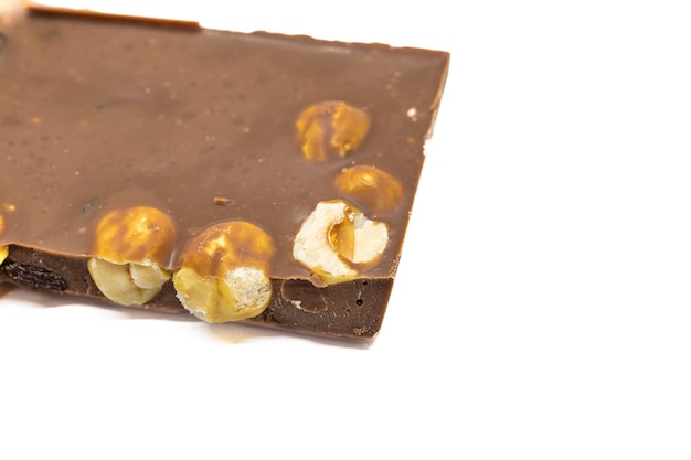 Milk chocolate bar with hazelnuts on white background