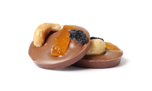 Milk chocolate candies with dry oranges and nuts isolated on a white background.