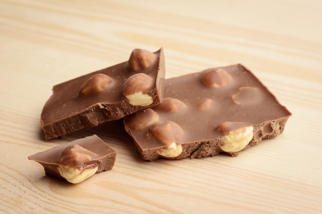 Milk chocolate with nuts on light wooden