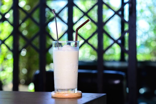 Milk churn on wooden table with the backdrop o