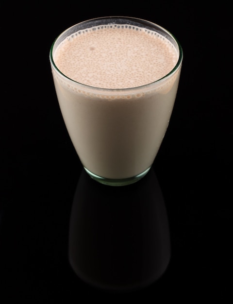 Milk cocktail in a glass on black