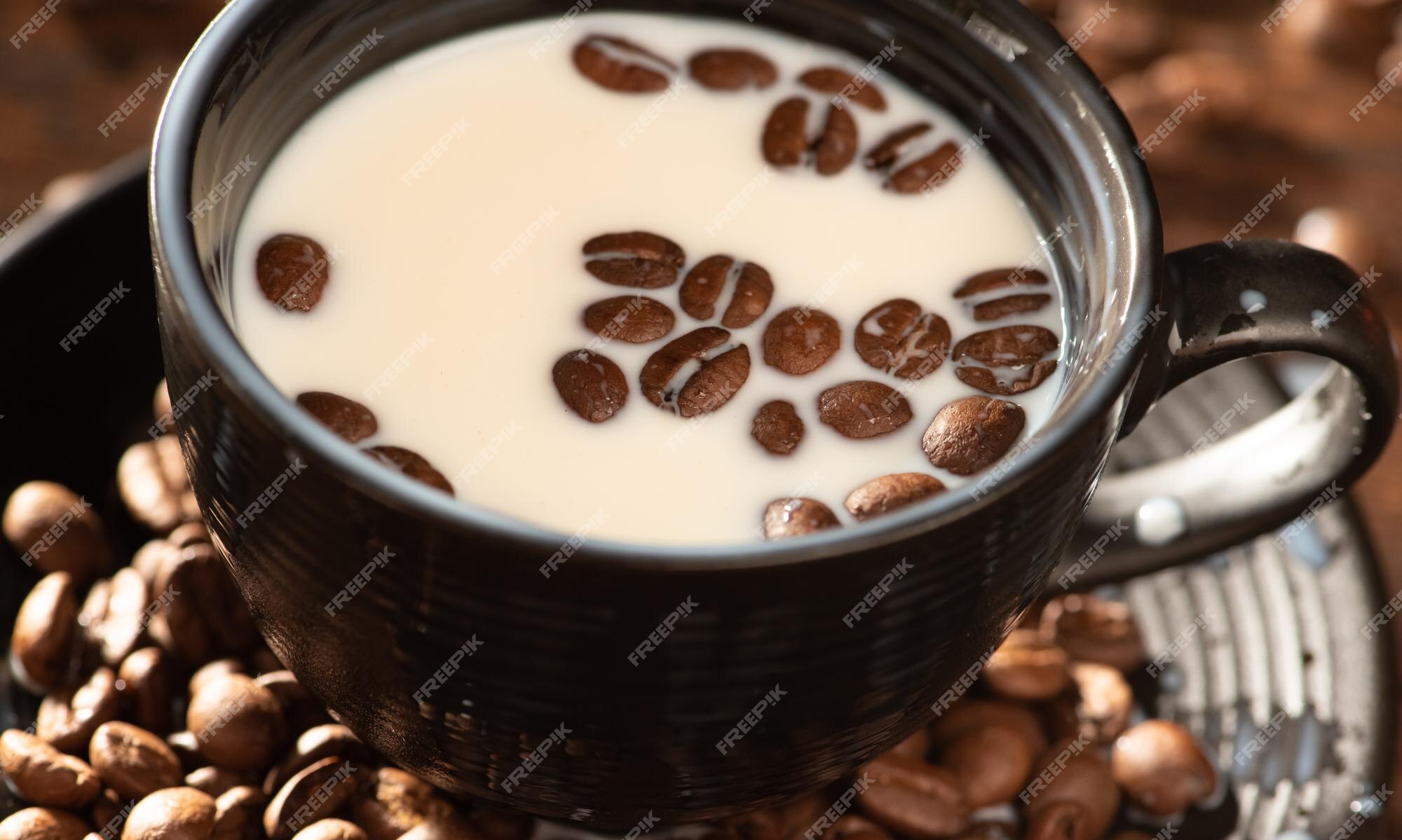 Premium Photo | Milk and coffee beans a black cup with milk and coffee