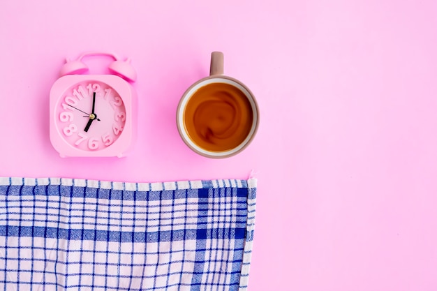 분홍색 배경에 격리된 우유 커피, 파란색 천, 알람 시계, 최소한의 개념 아이디어.