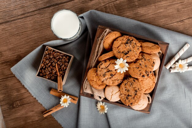 Milk, coffee box and cookies on table. top view