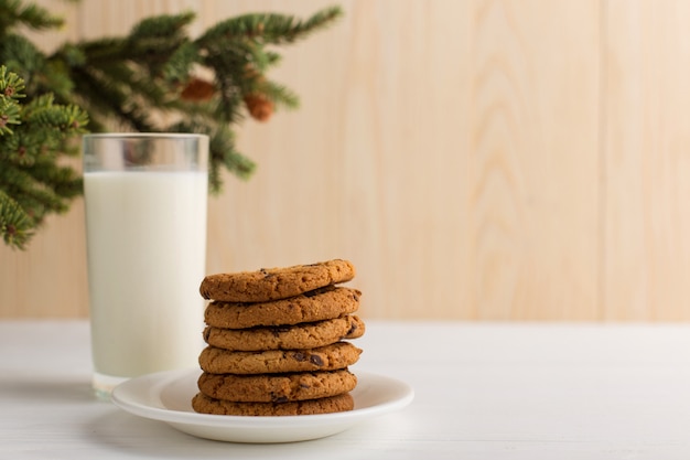 クリスマスツリーの下のサンタクロースのミルクとクッキー