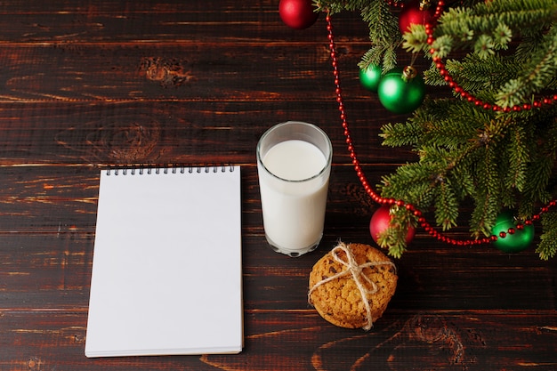 Milk, cookies and a wish list under the Christmas tree. The  of the arrival of Santa Claus.