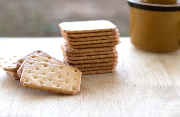 写真 ミルククラッカークッキー木製の机の上にコーヒーをお召し上がりいただけます