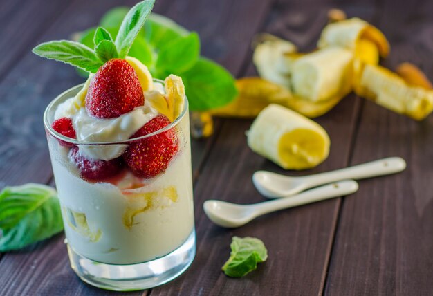 Milk dessert with strawberry and banana closeup