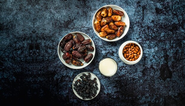 Milk dried dates fruit and apricot on dark background