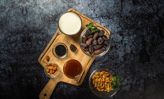 Milk dried dates fruit and apricot on dark background