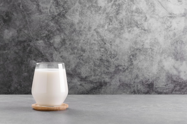 Photo milk in a glass on grey stone table minimal background with copy space