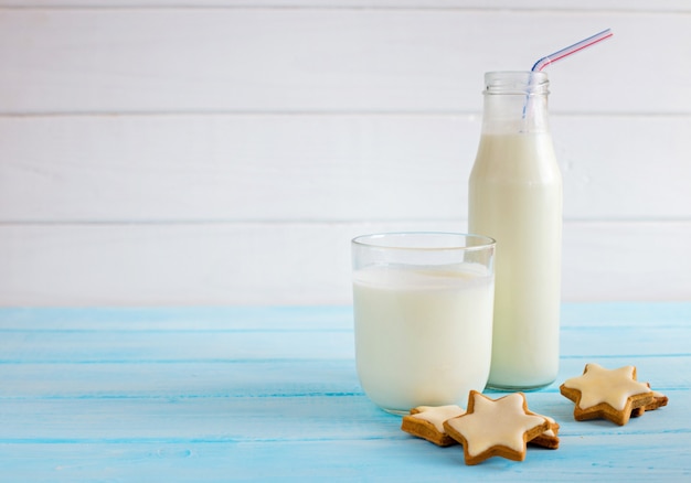 Milk in a glass on a light wooden 