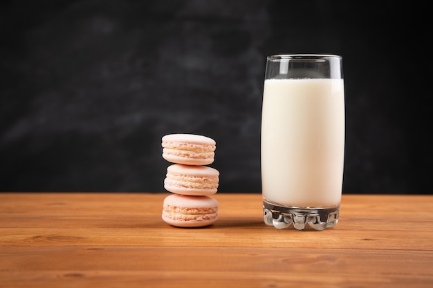 Milk in a glass and macaroon on the table