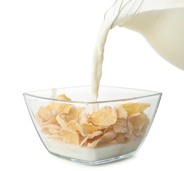 Milk is poured into a bowl with muesli, isolated