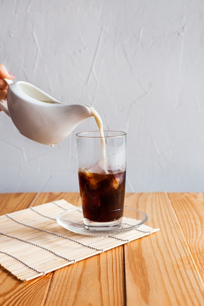 Milk is poured into iced coffee