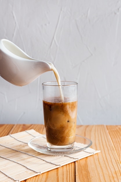Milk is poured into iced coffee
