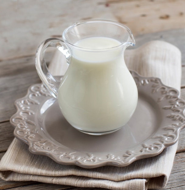 Milk in a jar on a napkin on a wooden table close up