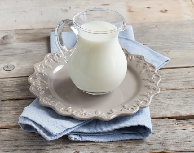 Milk in a jar on a napkin on a wooden table close up