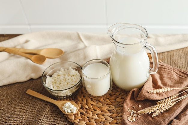 Milk jug and bowl of cottage cheese on wooden kitchen table