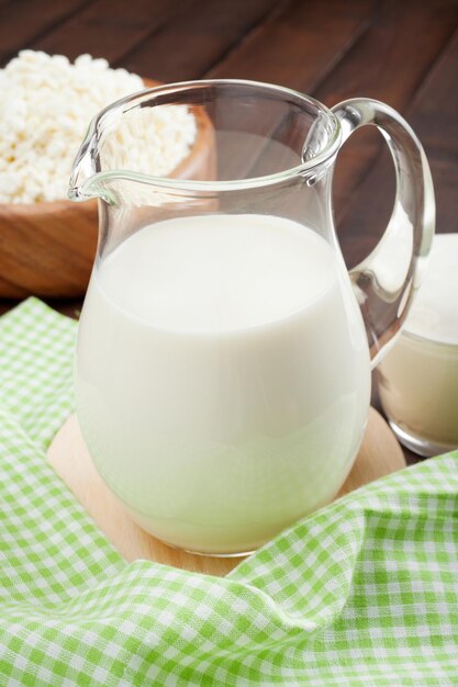 Foto ricotta in brocca di latte in piatto di legno rustico e panna acida