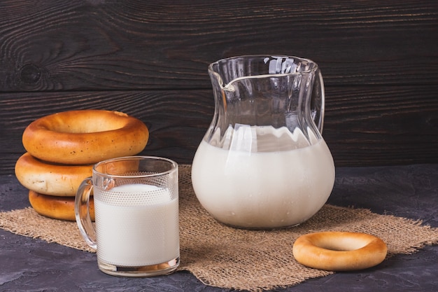 Milk in a jug and a cup of fresh bagels for breakfast