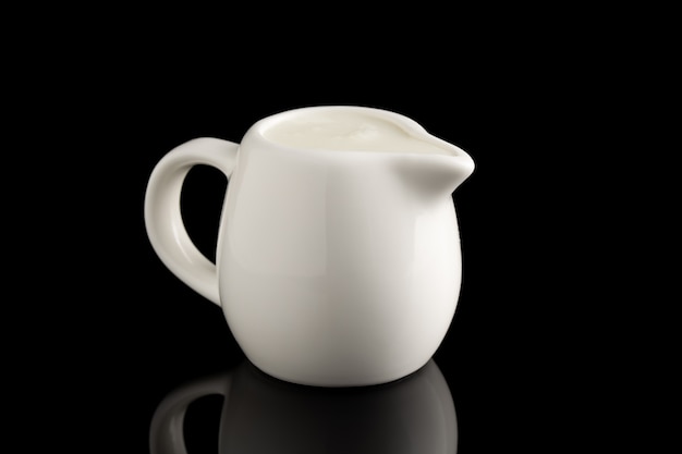 Milk jug isolated on black background