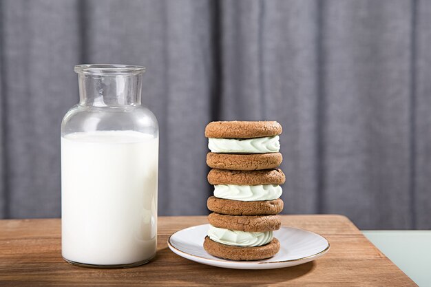 灰色の背景にミルクの水差しとクッキー